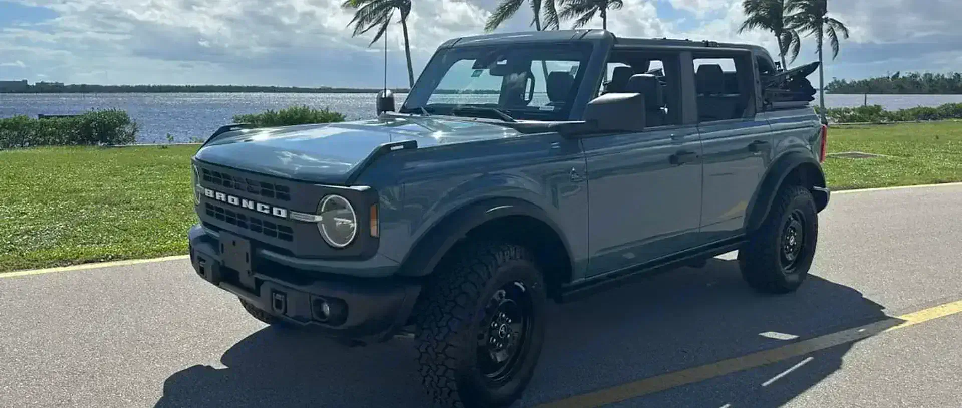 A 2022 Ford Bronco from the SWFL Auto Rentals fleet on a coastal road in Southwest Florida