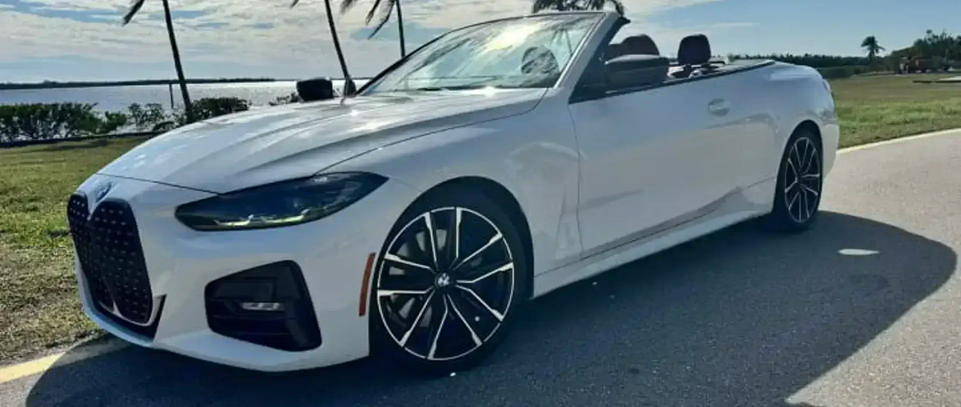 A 2023 BMW 430i convertible from the SWFL Auto Rentals fleet on a coastal road in Southwest Florida