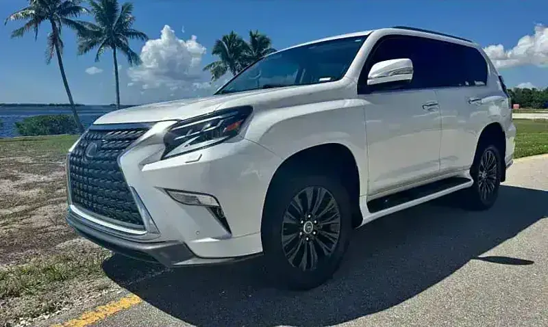A 2021 Lexus GX from the SWFL Auto Rentals fleet, parked on a palm-lined coastal road