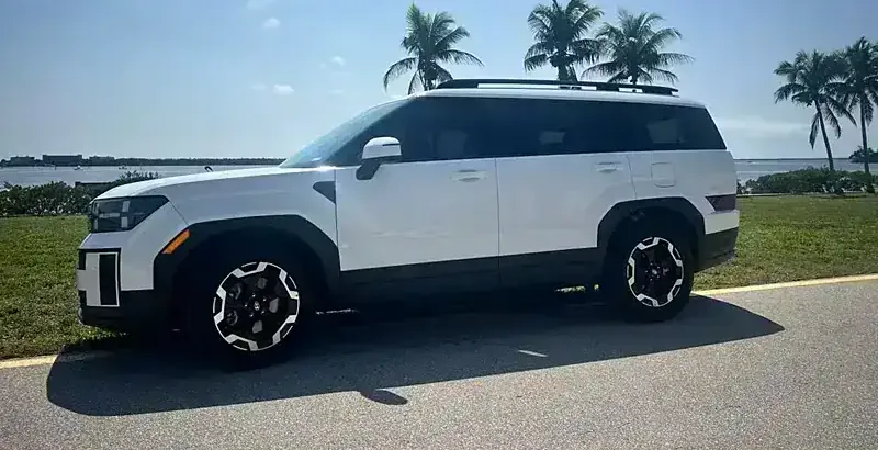 A 2024 Hyundai Santa Fe from the SWFL Auto Rentals fleet, parked on a paved road by the Gulf